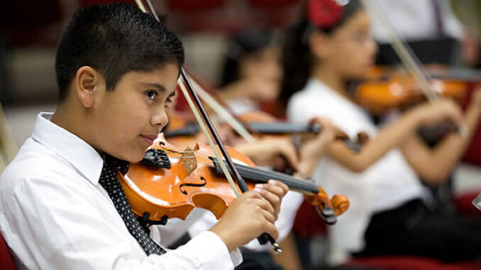 Young violinists play in an open concert with the orchestra. Photo: iStock