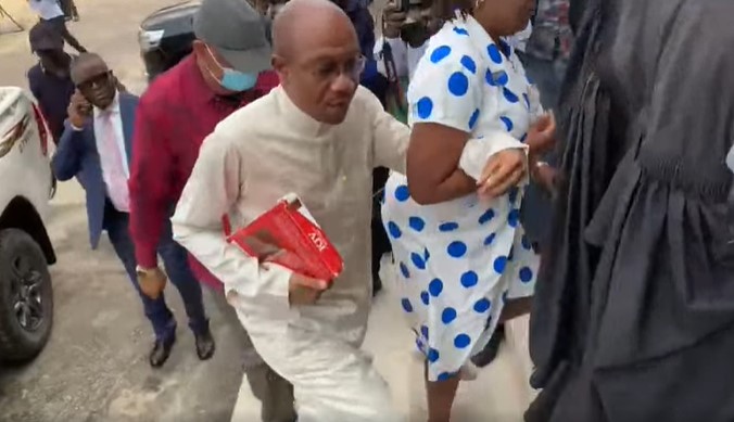 Emefiele in white attire, being supported by a female, on arrival at the High Court in Lagos, on Tuesday, July 25, 2023