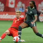 Super Falcons striker, Ifeoma Onumonu (right) in ball challenge against Canadian player