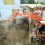 An excavator removes mud from a damaged house after heavy flooding in the Maidan Wardak province in the central of Afghanistan, Sunday, July 23, 2023.