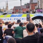 UK beefs up security in Leeds after riots result in burn of double-decker bus police vehicle overturning