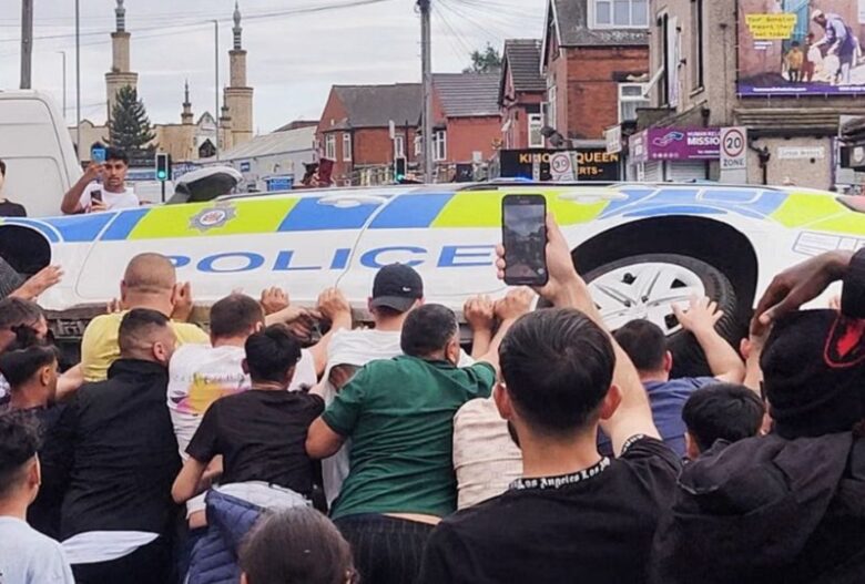 UK beefs up security in Leeds after riots result in burn of double-decker bus police vehicle overturning